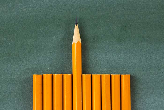 a sharpened pencil pushed higher than unsharpened ones